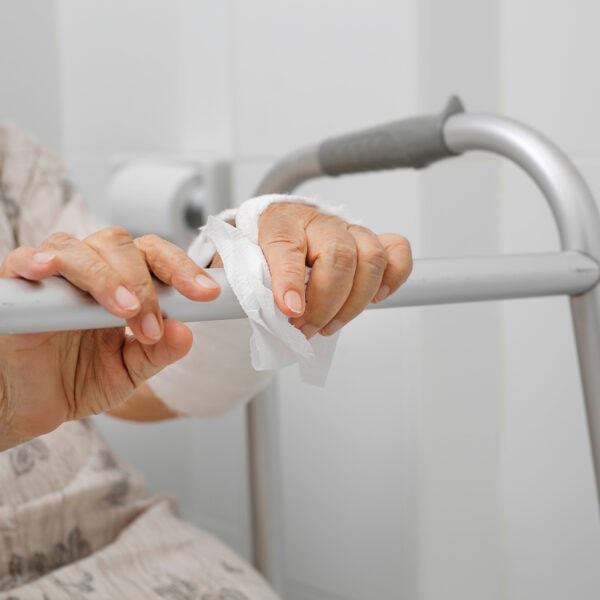 Senior woman with broken arm using the toilet with walker.