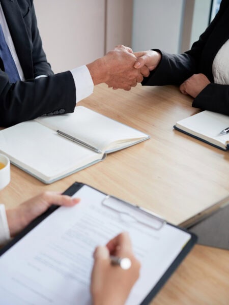 Close-up image of business partners shaking hands to confirm deal