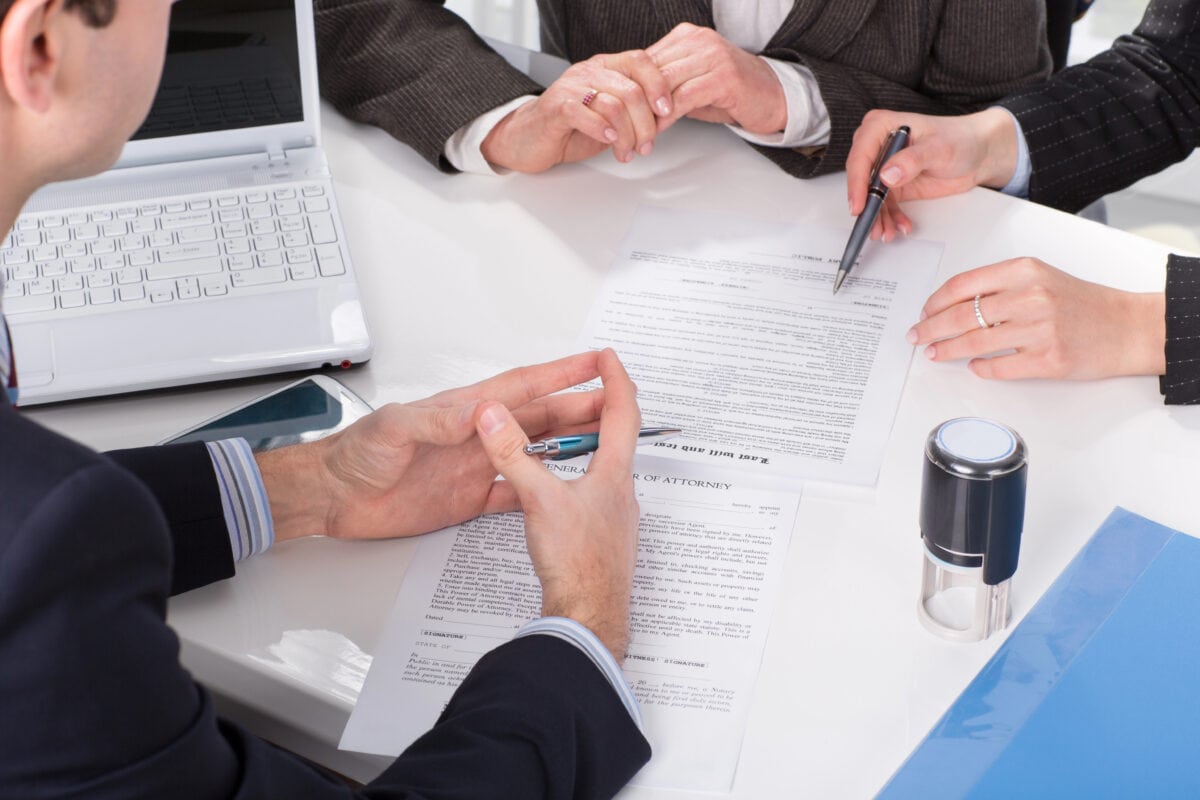 Hands of three people, signing documents