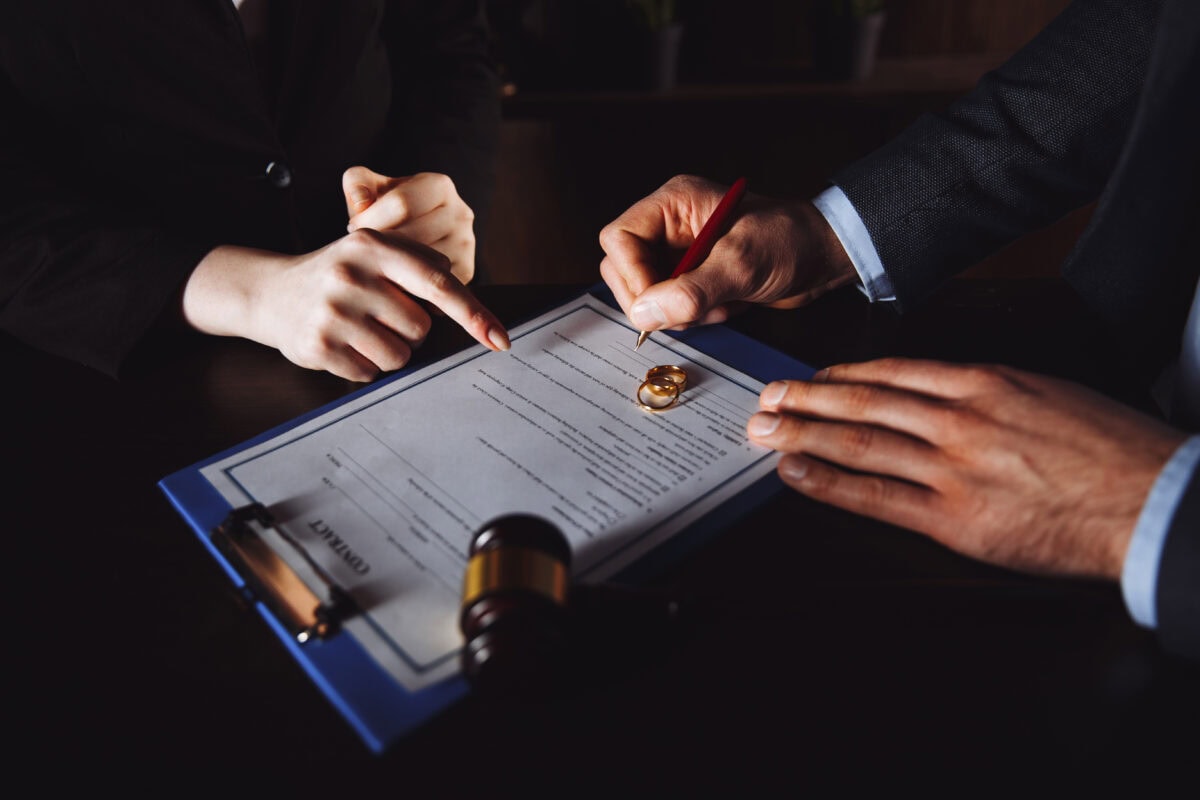 Divorce process. Man and woman sign documents because of broke up.