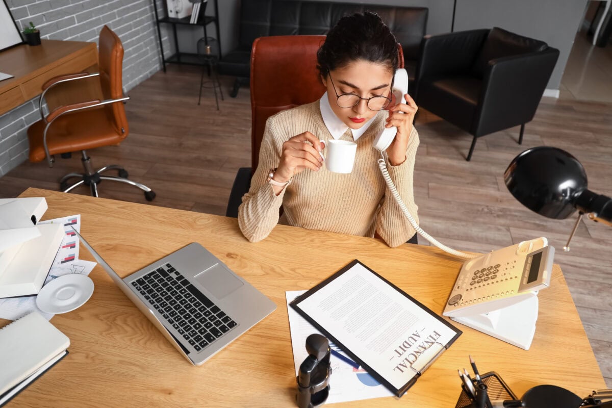 Female notary public talking by phone in office