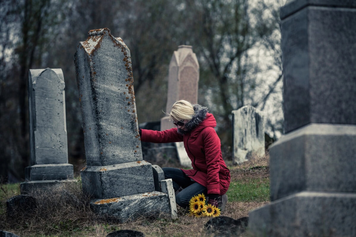 Woman with Sunflowers in a Cemetery